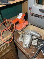 Zephyr saw and orange sander on workbench