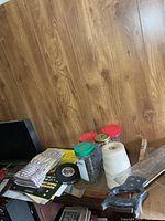 Mitre box, backsaw, jarred nails, roll of string, tape measure, gloves, sandpaper visible on tabletop