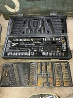 Closed case opened showing upper and lower trays with sockets and tools