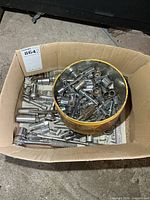 cardboard box with yellow tin filled with sockets