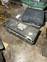 Closed toolboxes stacked with drill case on top