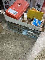 Overall lot showing plastic organizer with missing drawers, toolbox and cases on top