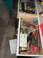 Open drawers showing casters, strap, various tools and hardware