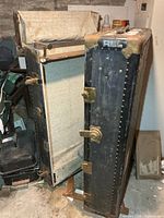 Trunk opened showing interior lining and hanging hardware