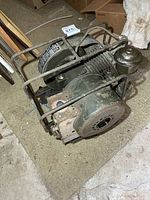 Oblique top view showing overall generator within protective cage and external pulley