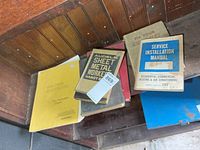 Stack of six trade manuals on wooden bench