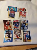 Overview of eight of the ten hockey cards laid out on white surface