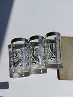 Three etched anniversary water glasses, front view
