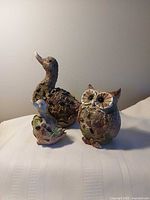 Three figurines grouped together showing relative sizes