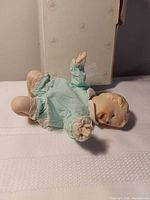 Doll lying on back displaying face, arms and outfit