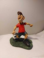 Front view of resin soccer player figurine on grass base