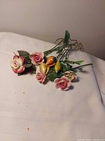 Group of eight porcelain flowers laying on cloth