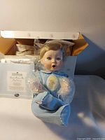 Doll seated in original box with protective wrapping
