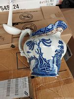 Side view of Booths Real Old Willow pitcher with ladle inside
