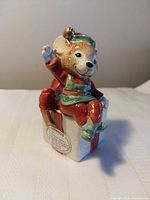 Mouse figurine seated on gift box showing overall design and color
