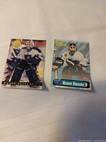 Both Manon Rheaume hockey cards side by side on table
