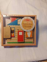 Front view of boxed Melissa & Doug First Play Peek-a-Boo House toy