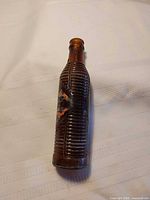 Full view of amber ribbed Orange Crush bottle front with remnants of paint