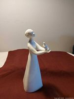 Full front view of white porcelain figurine holding dove