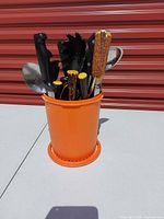 Full view of orange Tupperware holder with utensils