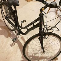 Overall view of black step-through bicycle with front rack