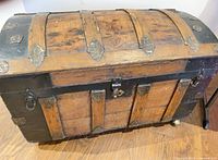 Front view showing wood slats, black metal trim, pressed metal hardware and center lock