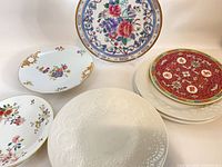 Group view of seven decorative plates showing variety of patterns and sizes