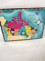 Front view of sealed coin set on map card showing all 13 coins
