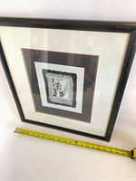 Front view of framed calligraphy print with measuring tape