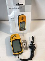 Full lot view showing Garmin eTrex GPS, owner’s manual and lanyard