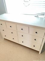 Front view of IKEA dresser showing eight drawers and black knobs