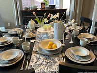 Table set showing dinner plates, bowls, salad plates, cups and serve pieces in use