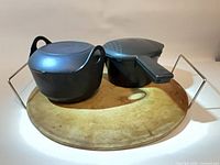 pizza stone with metal carrier and two plastic cookers on top