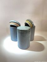 Front view of three blue-gray stoneware canisters with lids