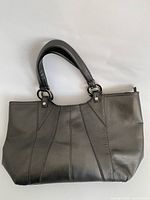 Front view of silver metallic faux leather tote showing panel stitching and dual handles
