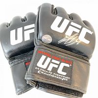 Front of gloves showing UFC logos, silver autograph, hologram sticker