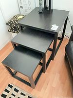 Three black nesting tables stacked