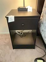 Full view of one nightstand showing drawer, knob and lower shelf