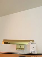 front view of brass picture light mounted on wall