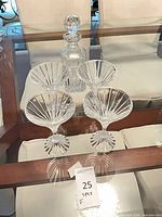 Full set: decanter with stopper and four glasses on glass table