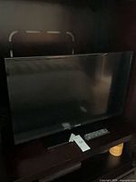 Front view of Samsung 32" TV on stand inside cabinet