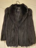 Front view of dark dyed fox fur jacket on hanger