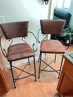 Front view of both bar stools showing upholstery and metal frames