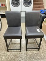 Front view of both dark brown faux leather counter stools