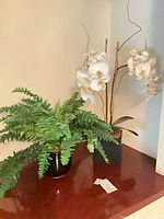 Both faux plants on surface showing overall appearance