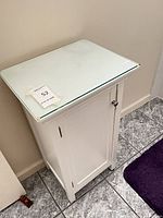 Full view of white cabinet with glass top