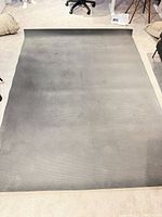 Full view of unrolled black rubber mat on floor