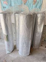Five foil-backed underlay rolls standing upright in plastic