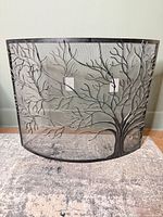 Front view of curved black metal fireplace screen