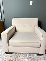 Front view showing tufted back, cushion, arms and legs